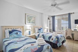 a bedroom with two beds and a ceiling fan at Relax with a Fabulous Ocean View Ocean Sounds in This 2 Bedroom 2 Bath Den in Port Aransas +32 photos