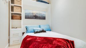 ein Schlafzimmer mit einem Bett mit einer roten Decke darauf in der Unterkunft City Side Near Cook Street Village in Victoria