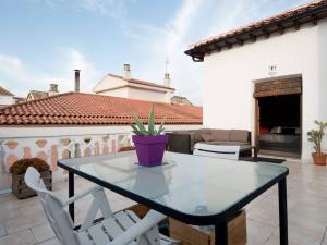 una mesa de cristal y sillas blancas en el patio en Loft wifi Centro espectacular terraza con todos los servicios, en Granada