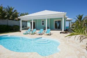 a house with a swimming pool in front of a house at Aqua Villa home in Governorʼs Harbour