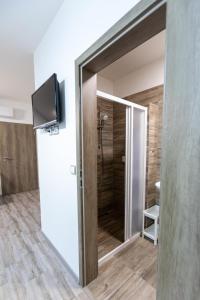 ein Bad mit einer Dusche und einer Glasschiebetür in der Unterkunft Apartmány Za Dvorem in Velké Pavlovice