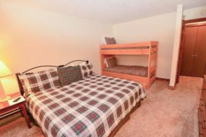 a small bedroom with a bed and a wooden shelf at Anaconda 101 in Copper Mountain