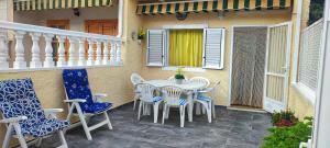 patio ze stołem i krzesłami na ganku w obiekcie Bungalow Deluxe Gran Alacant w mieście Gran Alacant