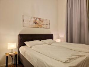 ein Schlafzimmer mit einem großen Bett mit weißer Bettwäsche in der Unterkunft Pension Mozart - Newly Renovated 2021 in Wien