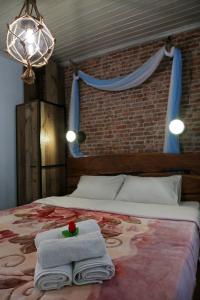 ein Bett mit Handtüchern und eine Blume darüber in der Unterkunft Kadmilos suites Samothraki in Samothráki