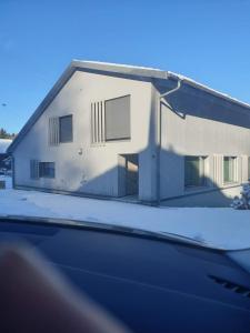 Una casa con nieve al costado. en Spacieux studio 38m2 avec sauna, en Les Paccots