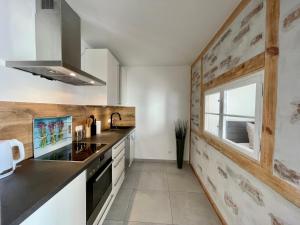 a kitchen with white counters and a window at Modernes Appartment mit Sauna nahe Burg im Spreewald in Vetschau