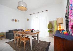 uma sala de estar com uma mesa e cadeiras e um sofá em Sardinia Beautiful Apartment em Calasetta