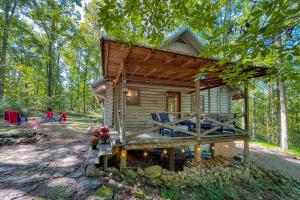 une cabine dans les bois avec une terrasse et des chaises dans l'établissement Cabin and Creek - Secluded Oasis - 3BD, à Kingston Springs