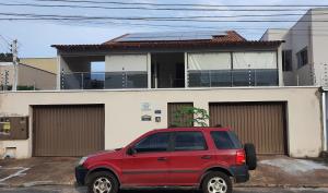 a red truck parked in front of a house at Apartamento no centro próximo a JK. in Palmas