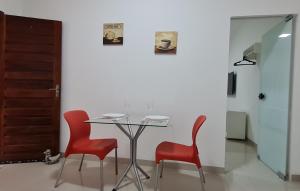 a table and two red chairs in a room at Apartamento no centro próximo a JK. in Palmas