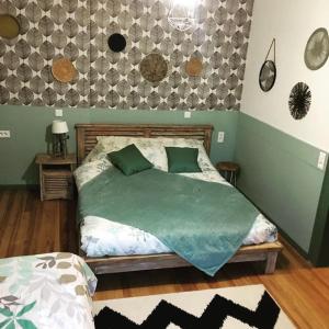 1 dormitorio con 1 cama con edredón verde en Côté Jardin, en Ornans
