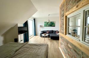 a living room with a couch and a brick wall at Modernes Appartment mit Sauna nahe Burg im Spreewald in Vetschau