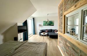 ヴェッチャウにあるModernes Appartment mit Sauna nahe Burg im Spreewaldのソファとレンガの壁のあるリビングルーム