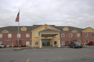a hotel with an american flag in a parking lot at Super 8 by Wyndham Rainsville in Rainsville
