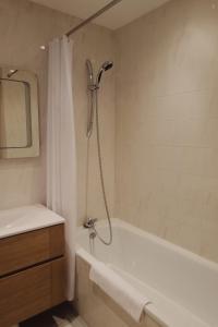 y baño con ducha, bañera y lavamanos. en Appartement La Tania, en Courchevel