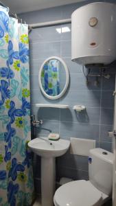 uma casa de banho com um WC, um lavatório e um espelho. em Sunday em Chornomorsk