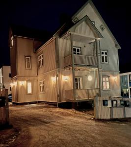 a large wooden house with lights on the side of it at Stetind - Modern apartment with free parking in Narvik