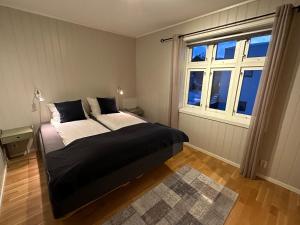 a bedroom with a large bed and a window at Stetind - Modern apartment with free parking in Narvik