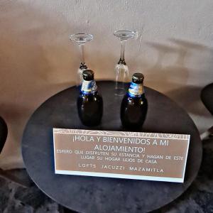two wine glasses sitting on a table with a sign at No 1 Loft Jacuzzi Mazamitla in Mazamitla