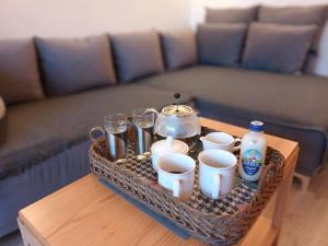 un vassoio con tazze e tazze su un tavolo con un divano di Modernes Apartment in Wien a Vienna