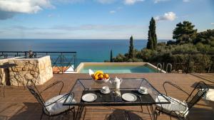 a table with a bowl of fruit on top of a patio at Xigia Escape villas in Khartáta