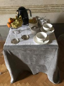 a table with a table cloth with cups and dishes on it at Domus '400 in Pisa