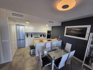 eine Küche mit einem Esstisch und eine Küche mit einem Kühlschrank in der Unterkunft Family Penthouse - Jacuzzi, Seaview Benidorm, Albir, Altea in Finestrat