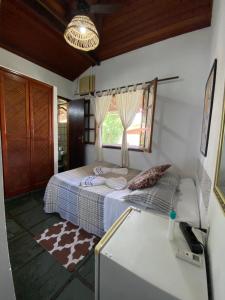 a bedroom with a bed and a window and a table at HTL PERSONALIZADA BUZIOS in Búzios