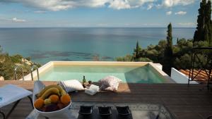 a bowl of fruit on a table next to a swimming pool at Xigia Escape villas in Khartáta