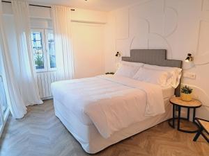 Un dormitorio blanco con una cama grande y una mesa en Apartamentos BEJAR - DUCAL, en Béjar