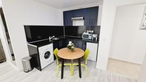 una pequeña cocina con mesa y microondas en Appartement très lumineux, en Sevran