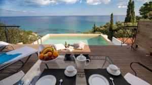 a table with a bowl of fruit next to a swimming pool at Xigia Escape villas in Khartáta