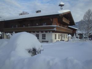 une maison avec un tas de neige devant elle dans l'établissement Oberransburg, à Flachau