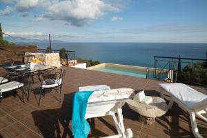 a patio with a table and chairs and the ocean at Xigia Escape villas in Khartáta