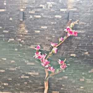 una rama con flores rosas en una pared de ladrillo en No 2 Loft Jacuzzi Mazamitla, en Mazamitla