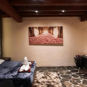 ein Schlafzimmer mit einem Gemälde an der Wand und einem Bett in der Unterkunft No 3 Loft Jacuzzi Mazamitla in Mazamitla