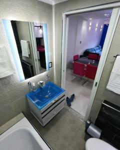 1 dormitorio y baño con lavabo azul. en Apartamento suite en capital en Buenos Aires