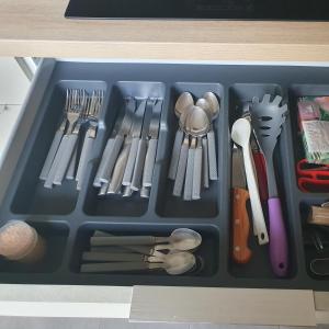 uma bandeja cheia de utensílios numa gaveta em L'Obernois situé dans 1 résidence privée em Obernai