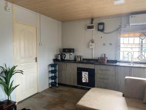 uma cozinha com uma mesa e uma porta num quarto em Samkab Legacy & Comfort em Lusaka