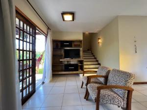 a living room with a tv and some chairs at Casa Linda Lençóis, Chapada Diamantina, Bahia in Lençóis