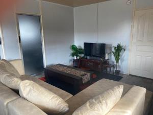 a living room with a couch and a tv at Samkab Legacy & Comfort in Lusaka