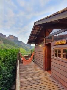 a wooden walkway leading to a building with mountains in the background at Rancho do Paioleiro in São Bento do Sapucaí +101 photos