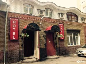 un edificio de ladrillo con dos letreros rojos. en Rest Home Hotel, en Nizhny Novgorod