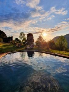 a large pool of water with the sunset in the background at Rancho do Paioleiro in São Bento do Sapucaí