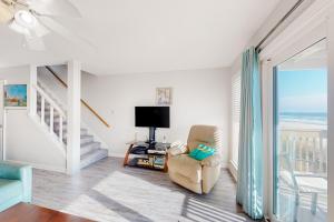 - un salon avec une chaise et une vue sur l'océan dans l'établissement Ramsgate Harbor 26, à Panama City Beach