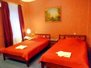 two beds in a hotel room with orange walls at Rest Home Hotel in Nizhny Novgorod