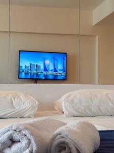 una camera da letto con TV a schermo piatto a parete di Orbi City in Batumi a Batumi