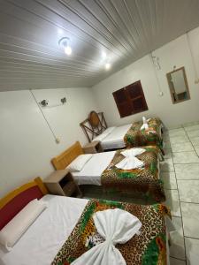 a room with three beds in a room at Pousada Encantos da Amazônia in Alter do Chao