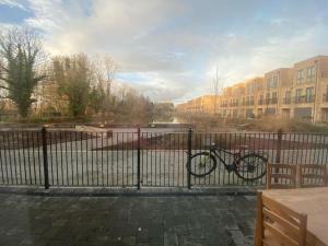 a bike parked behind a fence next to a building at Modern Spacious Bright 1-Bedroom Ground Floor Flat in Oxford